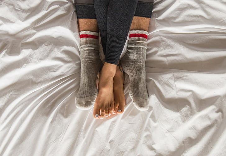 Couple in bed, pair of gray socks, man, woman, feet