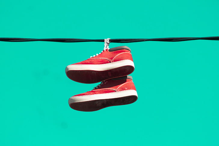 shoes, red, colored background, hanging, no people, close-up
