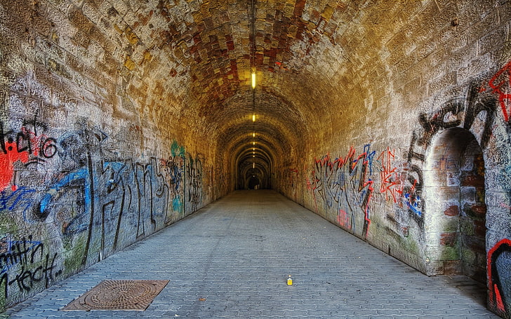 brown and white concrete tunnel with graffitis, architecture