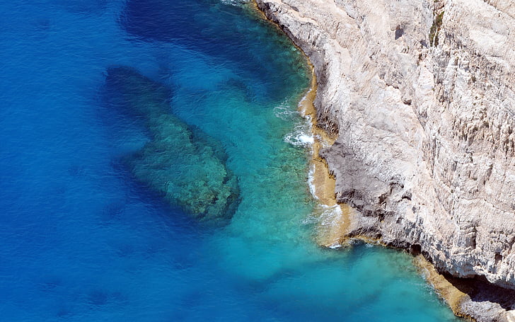 aerial photo of rocky cliff near large body of water, Navagio Beach